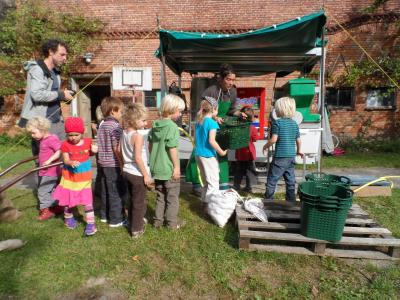 Kinder an der Saftpresse